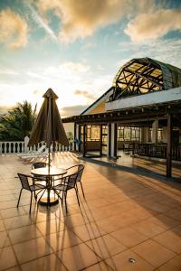 un patio con mesa y sombrilla en Hotel Costa Choco en Bahía Solano