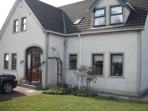Biały dom z czarnym dachem w obiekcie Narrow Gauge B&B w mieście Ballymoney