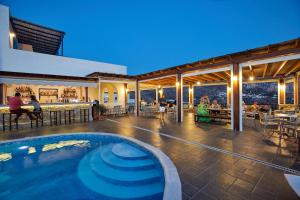 a swimming pool in the middle of a building with a restaurant at Vigla Hotel in Aegiali