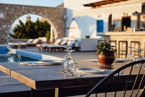 a wooden table with plates and glasses on top of a patio at Vigla Hotel in Aegiali
