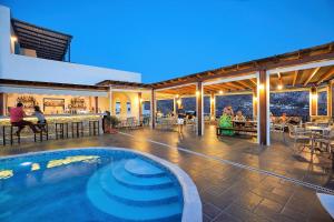 a swimming pool in the middle of a building with a restaurant at Vigla Hotel in Aegiali