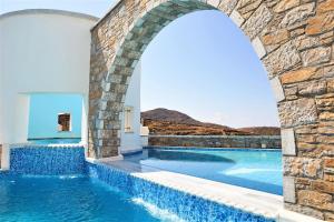 an infinity pool with an archway in a villa at Vigla Hotel in Aegiali