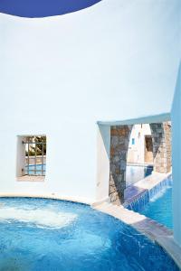 a swimming pool in a building with blue water at Vigla Hotel in Aegiali