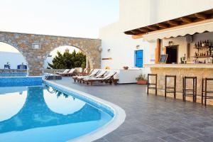 a villa with a swimming pool and a bar at Vigla Hotel in Aegiali