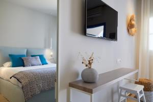 a bedroom with a bed and a television on the wall at Vigla Hotel in Aegiali
