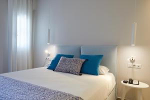 a bedroom with a bed with blue pillows on it at Vigla Hotel in Aegiali