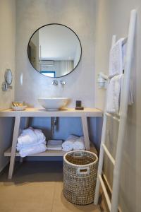 a bathroom with a sink and a mirror and towels at Vigla Hotel in Aegiali