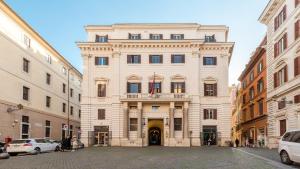 un grand bâtiment blanc au milieu d'une rue dans l'établissement Navona 7 Suite, à Rome