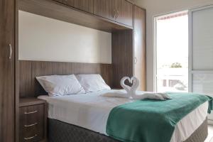 Un dormitorio con una cama con un cisne. en HANNA Flat Amsterdam - Canasvieiras, en Florianópolis