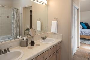 a bathroom with two sinks and a mirror and a bed at Luxurious Red Rock Vista Villa in Sedona +15 photos
