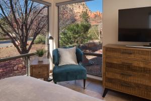 a bedroom with a large window with a tv and a chair at Luxurious Red Rock Vista Villa in Sedona