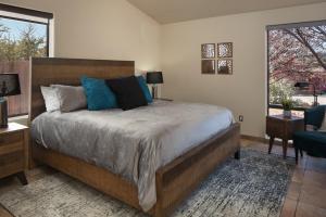 a bedroom with a large bed with blue pillows at Luxurious Red Rock Vista Villa in Sedona