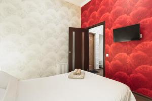 a bedroom with a white bed and a red wall at Modern Apartment in the city center in a new building in Odesa