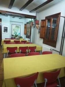 a conference room with yellow tables and red chairs at Albergue Albarracín in Albarracín