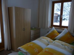 een slaapkamer met een bed met kussens en een raam bij Haus Bergwiese - für Naturfreunde, Familien, Wanderer in Gehlberg