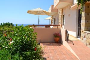a balcony of a house with an umbrella at Romantica Apartments in Falasarna