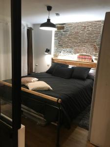1 dormitorio con 1 cama grande y pared de ladrillo en Les machines de Jules, hyper centre en Nantes