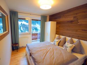 a bedroom with a large bed with a wooden wall at MarieindenBergen - Ihre private Unterkunft in Saalbach-Hinterglemm