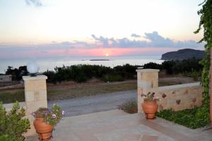 a patio with two flower pots and a view of the ocean at Romantica Apartments in Falasarna