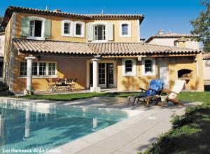 a house with a swimming pool in front of a house at Lagrange Vacances Domaine de Fayence in Fayence