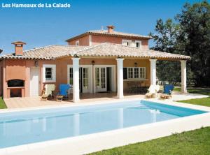 a villa with a swimming pool in front of a house at Lagrange Vacances Domaine de Fayence in Fayence