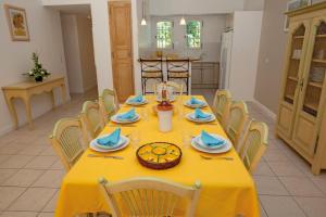 a yellow table with chairs and a yellow table cloth at Lagrange Vacances Domaine de Fayence in Fayence