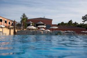 a swimming pool with chairs and umbrellas in a resort at Lagrange Vacances Domaine de Fayence in Fayence