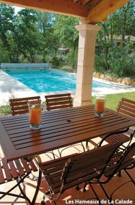 a wooden table with two glasses of orange juice on it at Lagrange Vacances Domaine de Fayence in Fayence