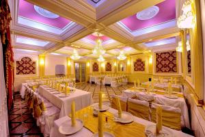 a banquet hall with white tables and chairs and purple ceilings at Hotel Rehoma in Piteşti
