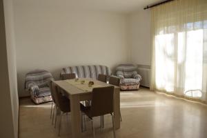 comedor con mesa, sillas y sofá en Appartamento Giuliana Cervia en Cervia