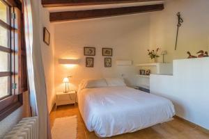 1 dormitorio con cama blanca y ventana en Cuixach - Stone mallorcan villa in Pollensa, en Pollensa