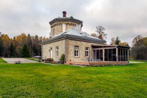 a building with a tower on top of a grass field at AirHome - Water Tower in Sõrve