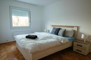 a bedroom with a large bed with a window at Riverside Pool Villa in Novi Sad