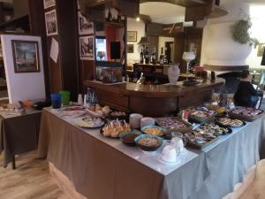una tavola con molti tipi di cibo diversi di Hotel I Larici a Bardonecchia