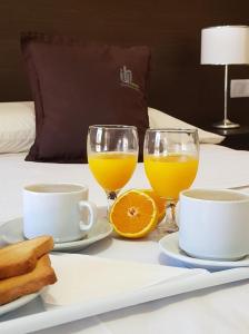 a table with two glasses of orange juice and toast at Iguazú Urban Hotel Express in Puerto Iguazú