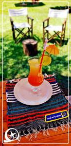 a drink on a plate with an umbrella on a table at HOTEL TRAVEL Encarnación in Encarnación