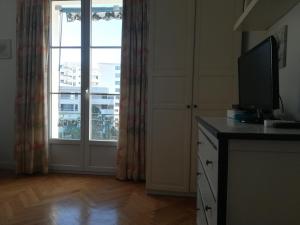 sala de estar con TV y ventana grande en Apartment Palais de Coppet, en Niza