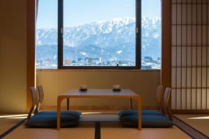 魚津市にあるホテルグランミラージュの山の景色を望むテーブルと椅子