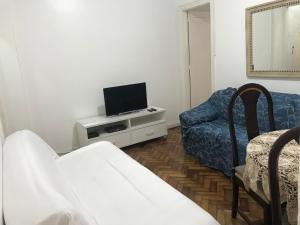 sala de estar con TV, sofá y silla en Apartamento Copacabana 876, en Río de Janeiro