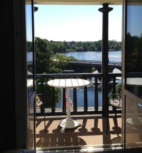 a balcony with a table and a view of a bridge at Grand Hotel Falkenberg in Falkenberg
