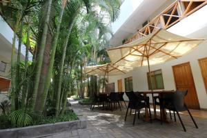 a patio with a table and chairs and palm trees at Casa Andina Standard Nasca in Nazca