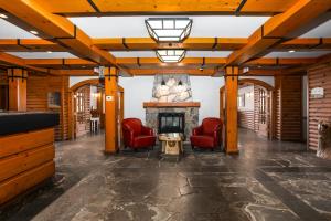 a lobby with red chairs and a fireplace at Lodge de la Montagne in Mont-Tremblant