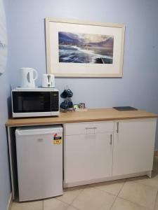un microondas en la parte superior de un mostrador en la cocina en Seadreams, Maroubra, en Sídney