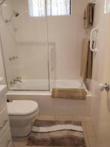 Un baño con ducha, inodoro y bañera. en Seadreams, Maroubra, en Sídney 12 fotos más