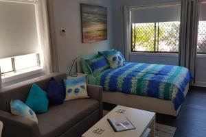 una sala de estar con una cama y un sofá en Seadreams, Maroubra, en Sídney