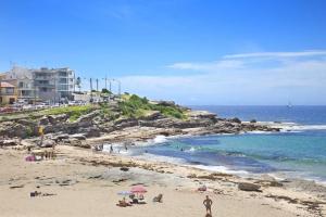 un grupo de personas en una playa cerca del océano en Seadreams, Maroubra, en Sídney