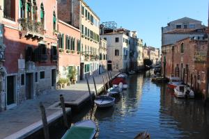un groupe de bateaux dans un canal entre bâtiments dans l'établissement La corte segreta, à Venise