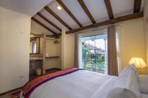 a bedroom with a bed and a large window at Luna House Cusco in Cusco