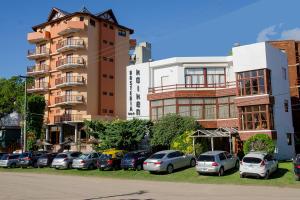 a row of cars parked in a parking lot in front of a building at Hosteria Kaiken II in Villa Gesell