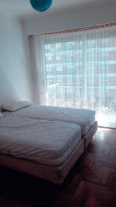 1 dormitorio con cama y ventana grande en Departamento PLENO CENTRO A 3 DE LA PLAYA en Mar del Plata
